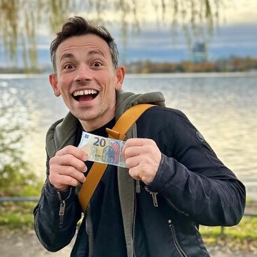 A man holding a 20 euro banknote