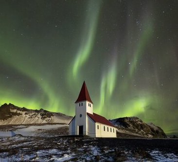 A church with a strong green aurora visible in the sky